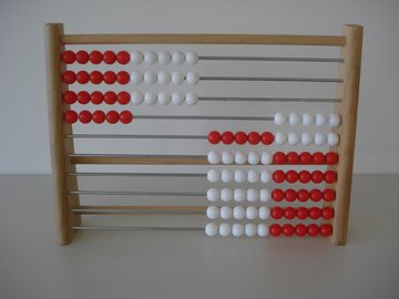 Rechenrahmen aus Holz mit weißen und roten Kugeln.