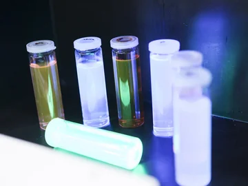 Mehrere schmale Gläser mit Deckel, die verschiedenfarbige chemische Lösungen enthalten.