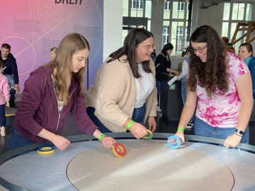 Studierende probieren die aktiven Mitmach-Stationen im Dynamikum aus.
