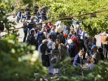 Eine größere Gruppe Tagungsteilnehmende steht in einem Innenhof, im Vordergrund Pflanzen