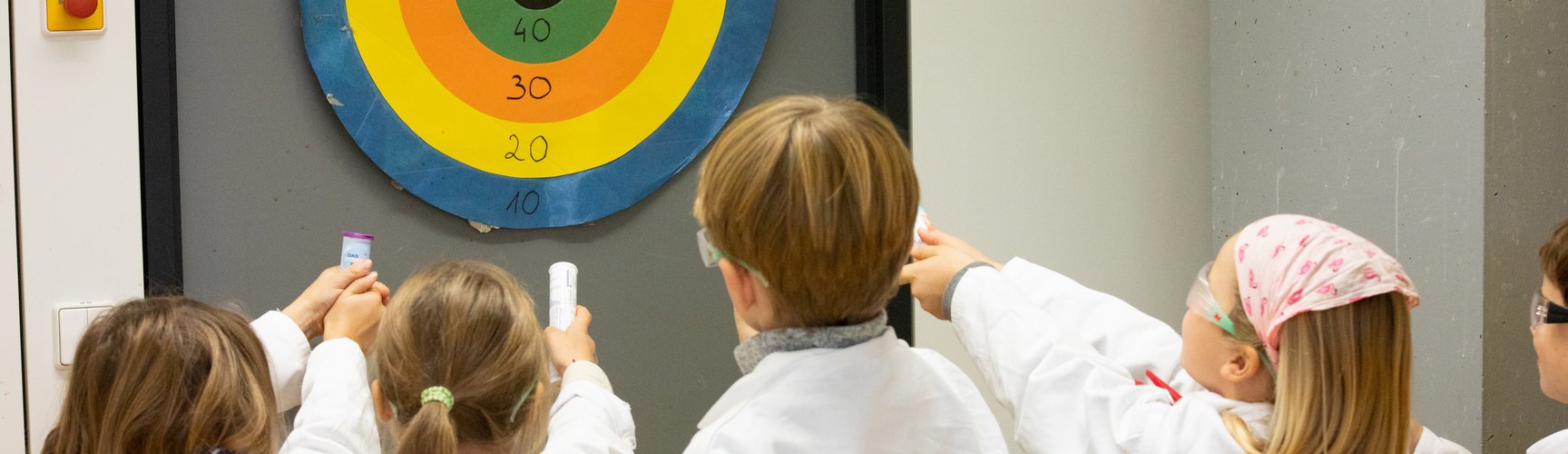 Kinder zielen auf eine Zielscheibe