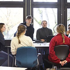 Dozent und Studierende am Tisch