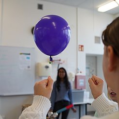 Zu sehen ist eine Schülerin von hinten, die ihren Ballon zum schweben bekommen hat.
