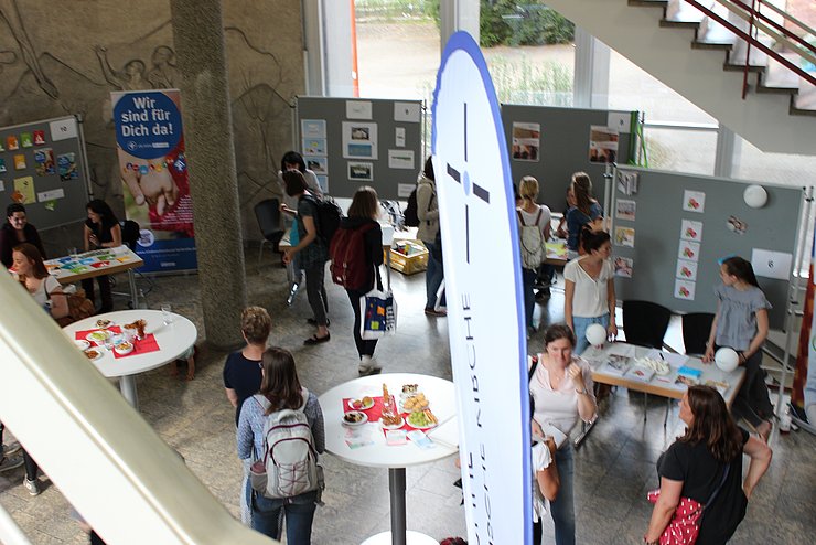 Blick von oben auf verschiedene Stände und Besucher:innen bei der Praxisbörse der Praxisstelle Kindheitspädagogik
