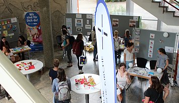Blick von oben auf verschiedene Stände und Besucher:innen bei der Praxisbörse der Praxisstelle Kindheitspädagogik